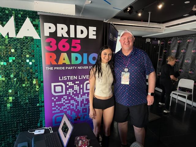 Artist Daya stands next to Houston by a Pride365 Radio Banner